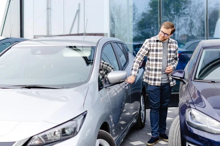 Person opening the door of a parked car