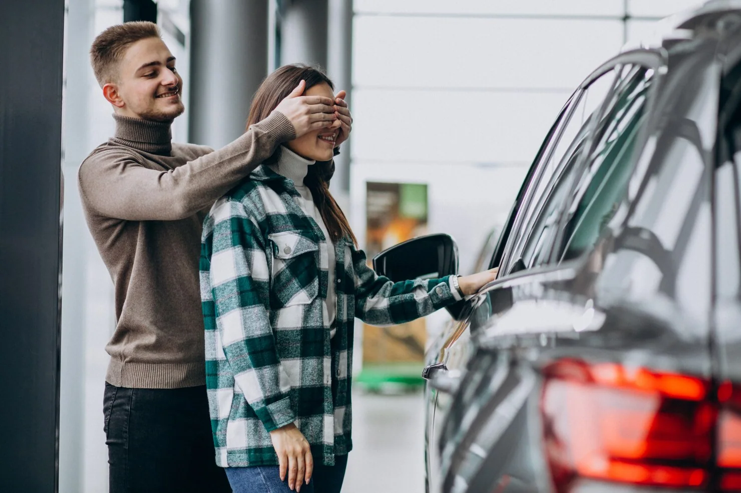 Two people standing beside a car